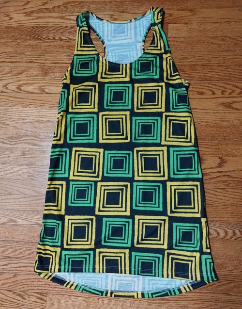 Flat lay of Jamaica colors racerback dress in black green and gold on wooden floor in JA Squared collection | Ohhh So Swag