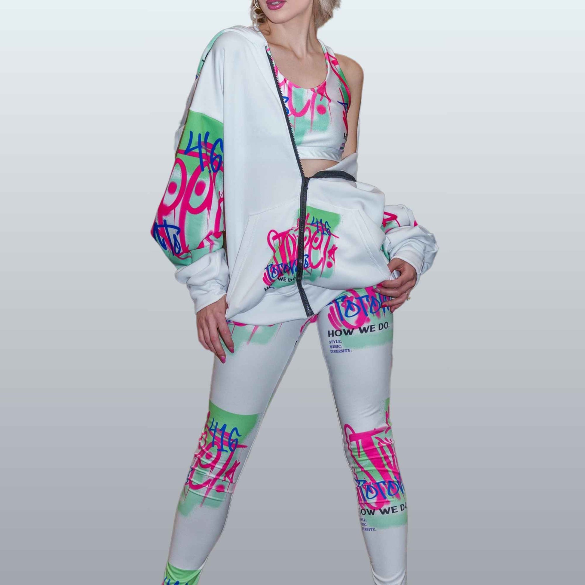 Cool young woman wearing a colorful unisex white and neon Toronto hoodie with zipper and white and neon Toronto leggings for women in a fashionable stance | Ohhh So Swag
