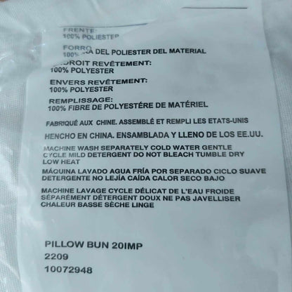 Text label on a pillow with fabric information and care instructions.